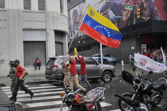 Pro-government supporters protest U.S. government imposed sanctions, marking May Day, or International Workers&#039; Day, in Caracas, Venezuela, on a rainy Saturday, May 1, 2021, amid the new coronavi ...