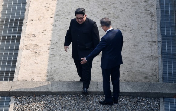 epa06695625 North Korean leader Kim Jong-un (L) crosses the military demarcation line (MDL) as South Korean President Moon Jae-in (R) greets him at the Joint Security Area (JSA) on the Demilitarized Z ...