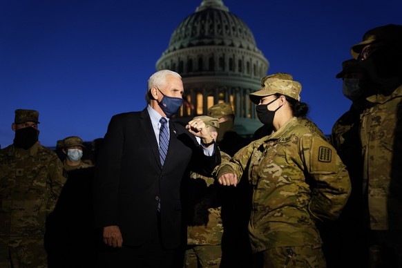 Vice President Mike Pence elbow bumps with a member of the National Guard as he speaks to troops outside the U.S. Capitol, Thursday, Jan. 14, 2021, in Washington. (AP Photo/Alex Brandon, Pool)