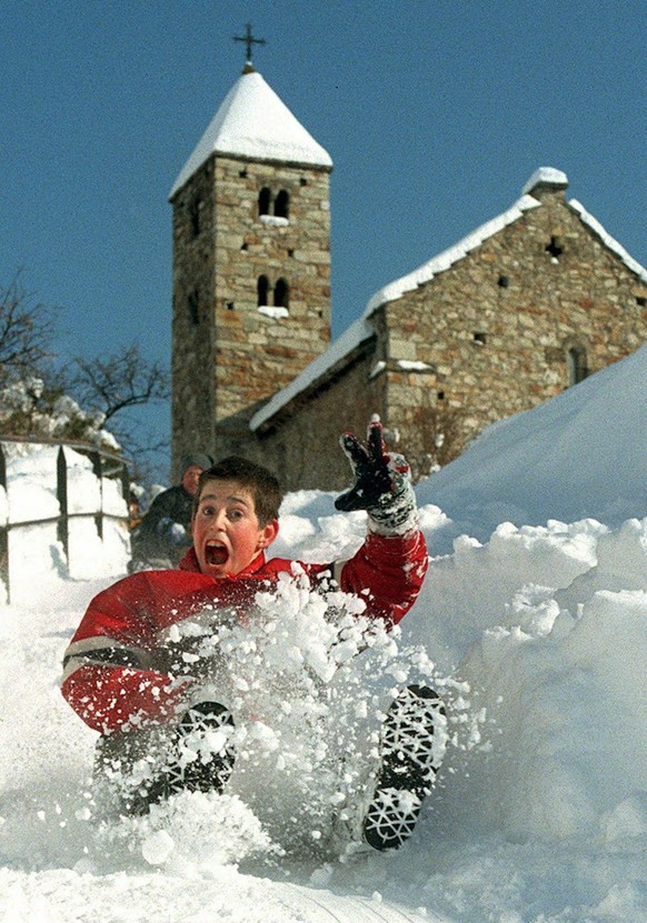 Un ecolier descent en luge le chemin conduisant a l&#039;eglise de Valere sur la colline au-dessus de Sion VS, ce 10 fevrier 1999, au lendemain des fortes chutes de neige qui sont tombee sur la Suisse ...