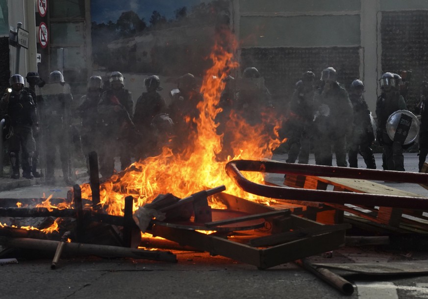 Police face a burning barricade during protests Saturday, Sept. 21, 2019, in Hong Kong. Demonstrators have marched through an outlying district of Hong Kong in another weekend of protest aimed at the  ...