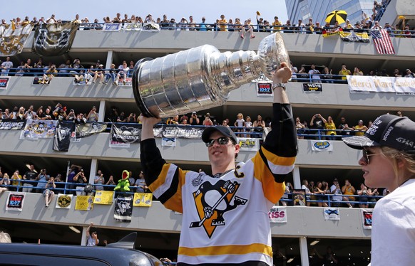 Pittsburgh Penguins&#039; Sidney Crosby hoists the Stanley Cup during the team&#039;s Stanley Cup NHL hockey victory parade on Wednesday, June 14, 2017, in Pittsburgh. (AP Photo/Gene J. Puskar)