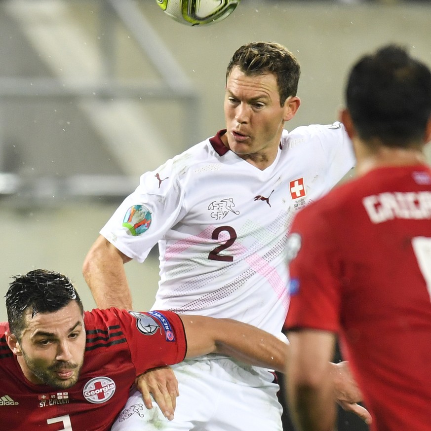 Switzerland&#039;s defender Stephan Lichtsteiner, center, fights for the ball with Georgia&#039;s Davit Khocholava, left, during the UEFA Euro 2020 qualifying Group D soccer match between Switzerland  ...