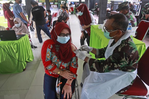 A woman receives a shot of the Sinovac vaccine for COVID-19 during a mass vaccination held by Indonesia military in Medan, North Sumatra, Indonesia, Wednesday, June 23, 2021. The world&#039;s fourth m ...