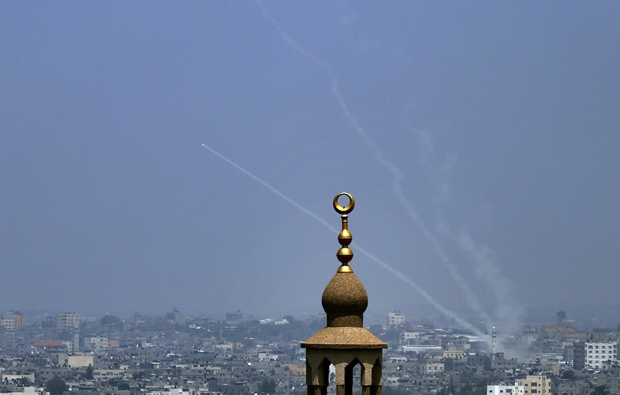 Smoke trails are seen as rockets are launched from the Gaza Strip towards Israel, in Gaza City, Saturday, July 14, 2018. The Israeli military carried out its largest daytime airstrike campaign in Gaza ...