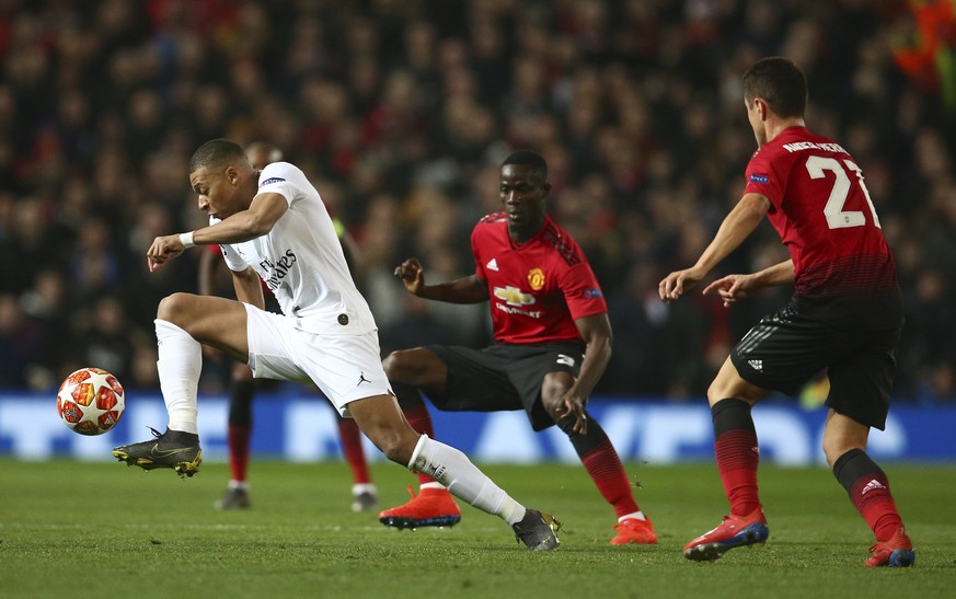 Paris Saint Germain&#039;s Kylian Mbappe, left controls the ball as Manchester United&#039;s Ander Herrera, right, looks on during the Champions League round of 16 soccer match between Manchester Unit ...