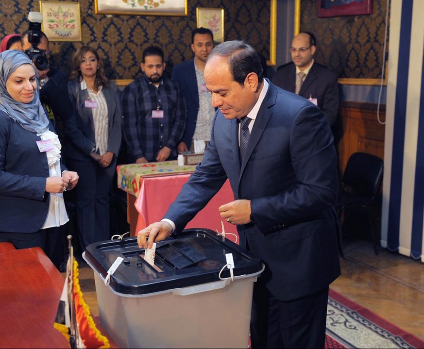 epa06629918 A handout photo made available by the Egyptian Presidency shows Egyptian President Abdel Fattah al-Sisi casting his ballot paper during day one of the presidential elections at a polling s ...