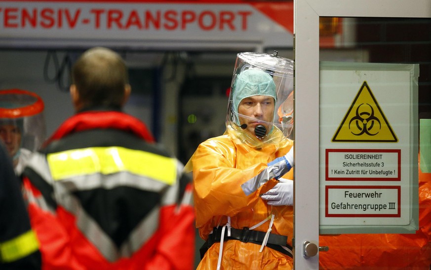 Gesundheitsspezialisten am Flughafen Frankfurt erwarten die Ankunft eines Ebola-Patienten – die Mitarbeiter der Universitätsklinik tragen spezielle Schutzanzüge, die eine Infektion verhindern sollen.