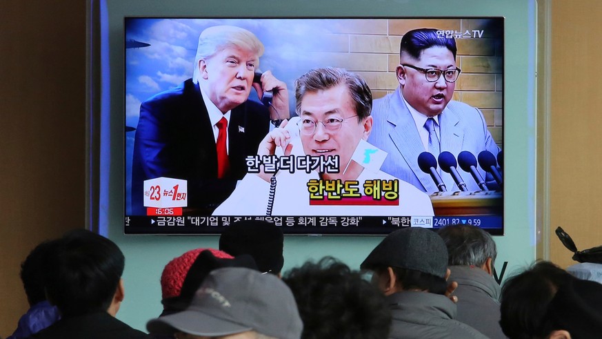 FILE - In this March 7, 2018 file photo, People watch a TV screen showing images of North Korean leader Kim Jong Un, right, South Korean President Moon Jae-in, center, and U.S. President Donald Trump  ...