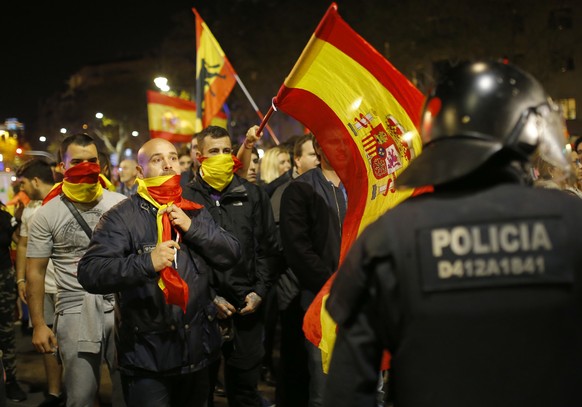 Holding Spanish flags, demonstrators confront Catalan police as they are prevented from moving forward during a march against the unilateral declaration of independence approved earlier by the Catalan ...