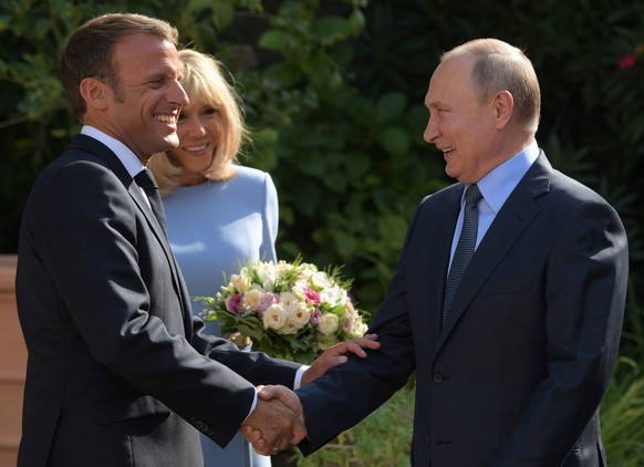 epa07781209 French President Emmanuel Macron (L) and his wife Brigitte Macron (C) welcome Russian President Vladimir Putin (R) at the fort of Bregancon in France, 19 August 2019. President Putin pays  ...