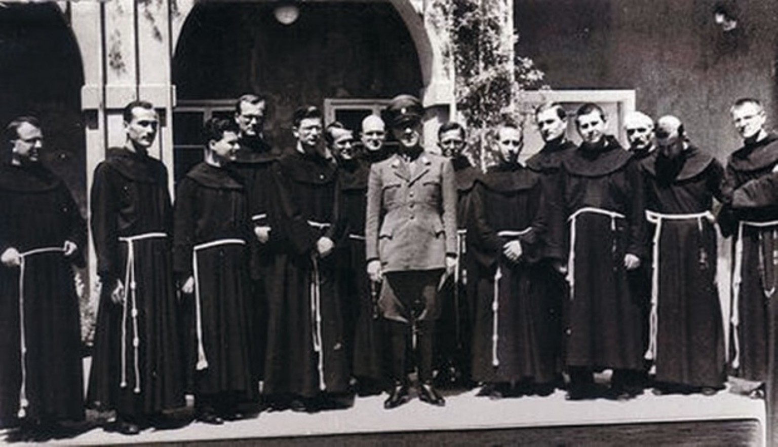 Pavelic posiert mit Mönchen des Franziskanerordens, 1940er.