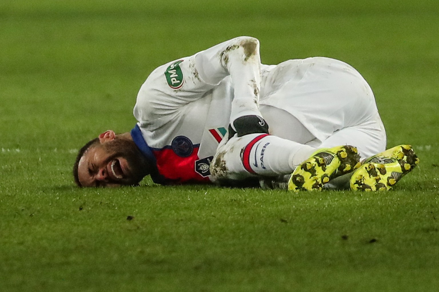epa09002491 Neymar Jr of Paris Saint Germain lies injured on the pitch during the Coupe de France round of 32 soccer match between SM Caen and PSG in Caen, north western France, 10 February 2021. EPA/ ...