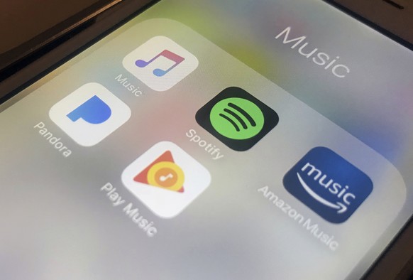 ADDS TO CLARIFY SPOTIFY IS NOT RAISING MONEY - FILE - This Jan. 28, 2018, file photo shows music streaming apps clockwise from top left, Apple, Spotify, Amazon, Pandora and Google on an iPhone in New  ...