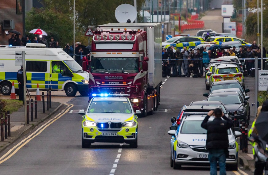epa07943575 Police drive the lorry container along the road from the scene in Waterglade Industrial Park in Grays, Essex, Britain, 23 October 2019. A total of 39 bodies were discovered inside a lorry  ...