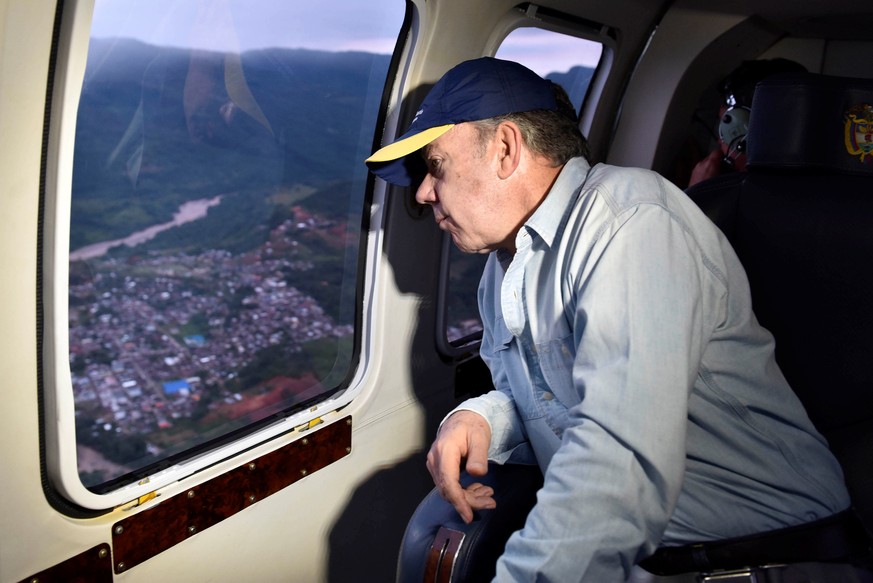 Colombia&#039;s President Juan Manuel Santos overflies a flooded area after heavy rains caused several rivers to overflow, pushing sediment and rocks into buildings and roads in Mocoa, Colombia April  ...