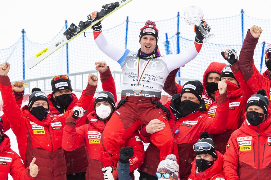 Winner Beat Feuz of Switzerland and team celebrate with the crystal globe of the overall men&#039;s downhill competition during the podium at the FIS Alpine Skiing World Cup finals, in Parpan-Lenzerhe ...