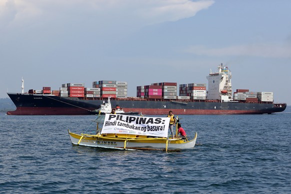 epa07612047 A handout photo made available by Greenpeace shows environmental activists displaying a banner reading &#039;Philippines is not a dumpsite&#039; next to the cargo ship MV Bavaria, the vess ...