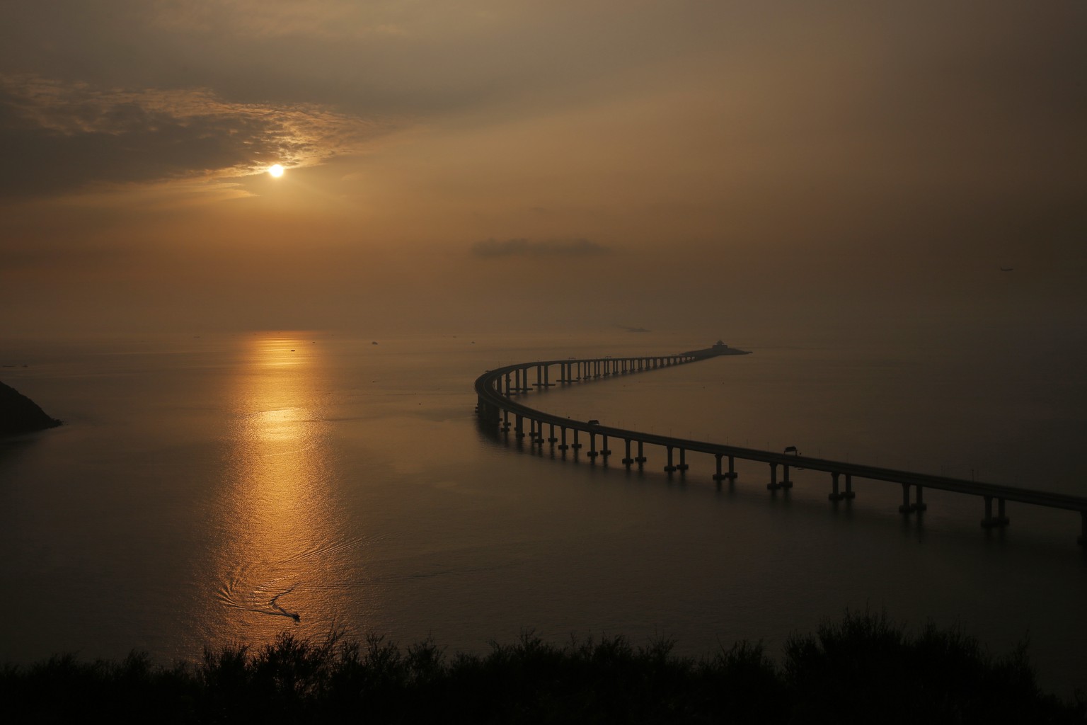 The Hong Kong-Zhuhai-Macau Bridge is seen against the sunset in Hong Kong, Monday, Oct. 22, 2018. The bridge, the world&#039;s longest cross-sea project, which has a total length of 55 kilometers (34  ...