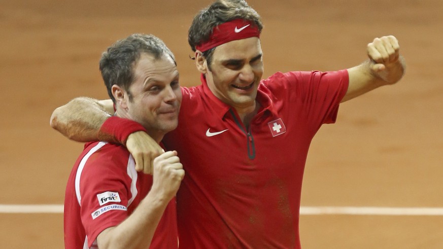 Swiss coach Severin Luthi, left, and Switzerland&#039;s Roger Federer celebrate after Federer defeated France&#039;s Richard Gasquet in the Davis Cup final between France and Switzerland at Stade Pier ...