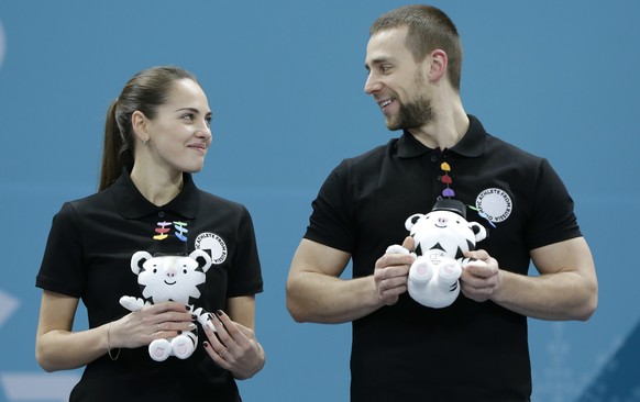 Third placed curlers Russian athletes Anastasia Bryzgalova, left, and Aleksandr Krushelnitckii smile at each other at the podium during the venue ceremony after the mixed doubles final curling match a ...