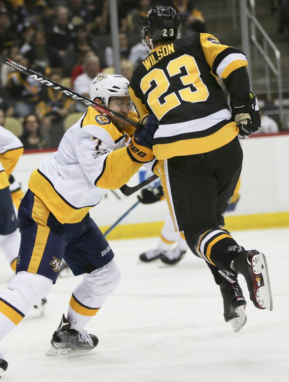 Pittsburgh Penguins&#039; Scott Wilson (23) hops into the air as he is checked by Nashville Predators&#039; Yannick Weber in the second period of the NHL hockey game, Saturday, Oct. 7, 2017, in Pittsb ...