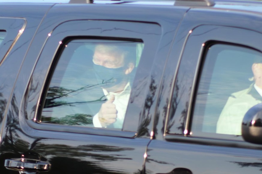 President Donald Trump drives past supporters gathered outside Walter Reed National Military Medical Center in Bethesda, Md., Sunday, Oct. 4, 2020. Trump was admitted to the hospital after contracting ...