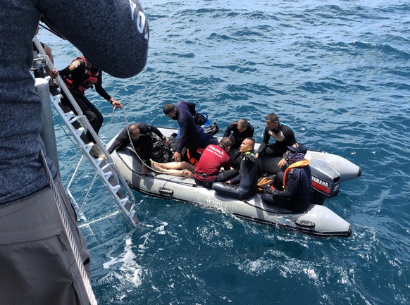 epaselect epa06867114 Thai officials from the navy, marine police and rescue workers transport the body of a tourist after a boat sank, as search and rescue operations continue in the seas off Phuket  ...