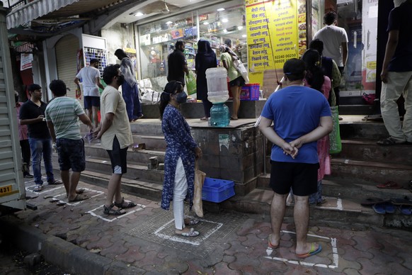 People stand in a queue maintaining physical distance to buy grocery outside a store during the coronavirus pandemic in Mumbai, India, Wednesday, March 25, 2020. The world&#039;s largest democracy wen ...