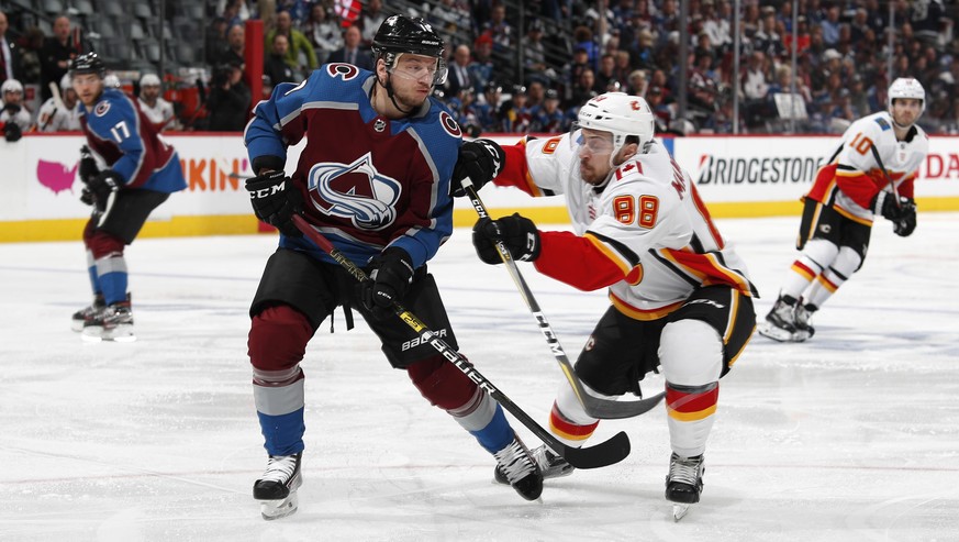 Calgary Flames left wing Andrew Mangiapane, right, checks Colorado Avalanche right wing Sven Andrighetto after Andrighetto had passed the puck during the second period of Game 4 of an NHL hockey playo ...