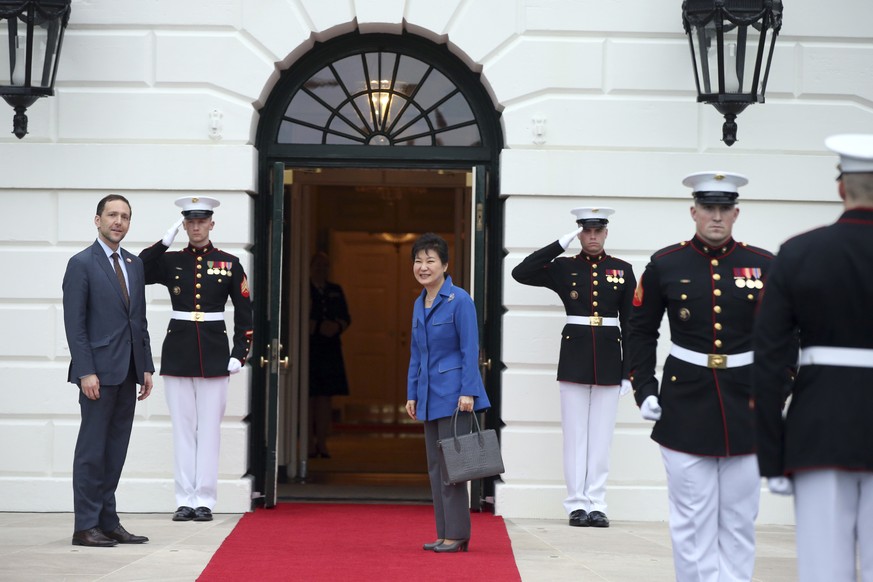 South Korean President Park Geun hye, center, pauses after she is greeted by Ambassador Peter A. Selfridge, left, Chief of Protocol of the United States, upon her arrival at the White House in Washing ...