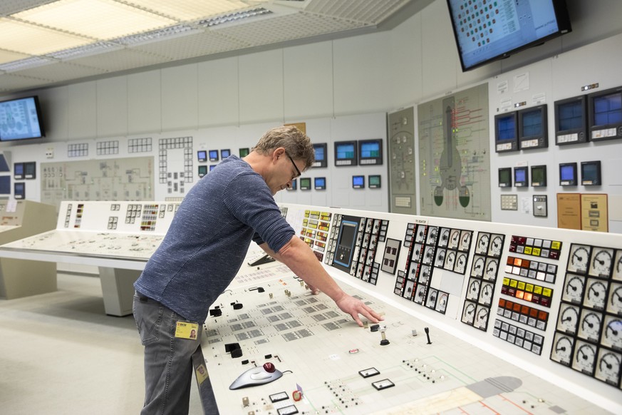 The reactor operator pushes the buttons to power down the reactor during the official shutdown of the Muehleberg nuclear power plant after 47 years of operation, on Friday, 20 December 2019, in Muehle ...
