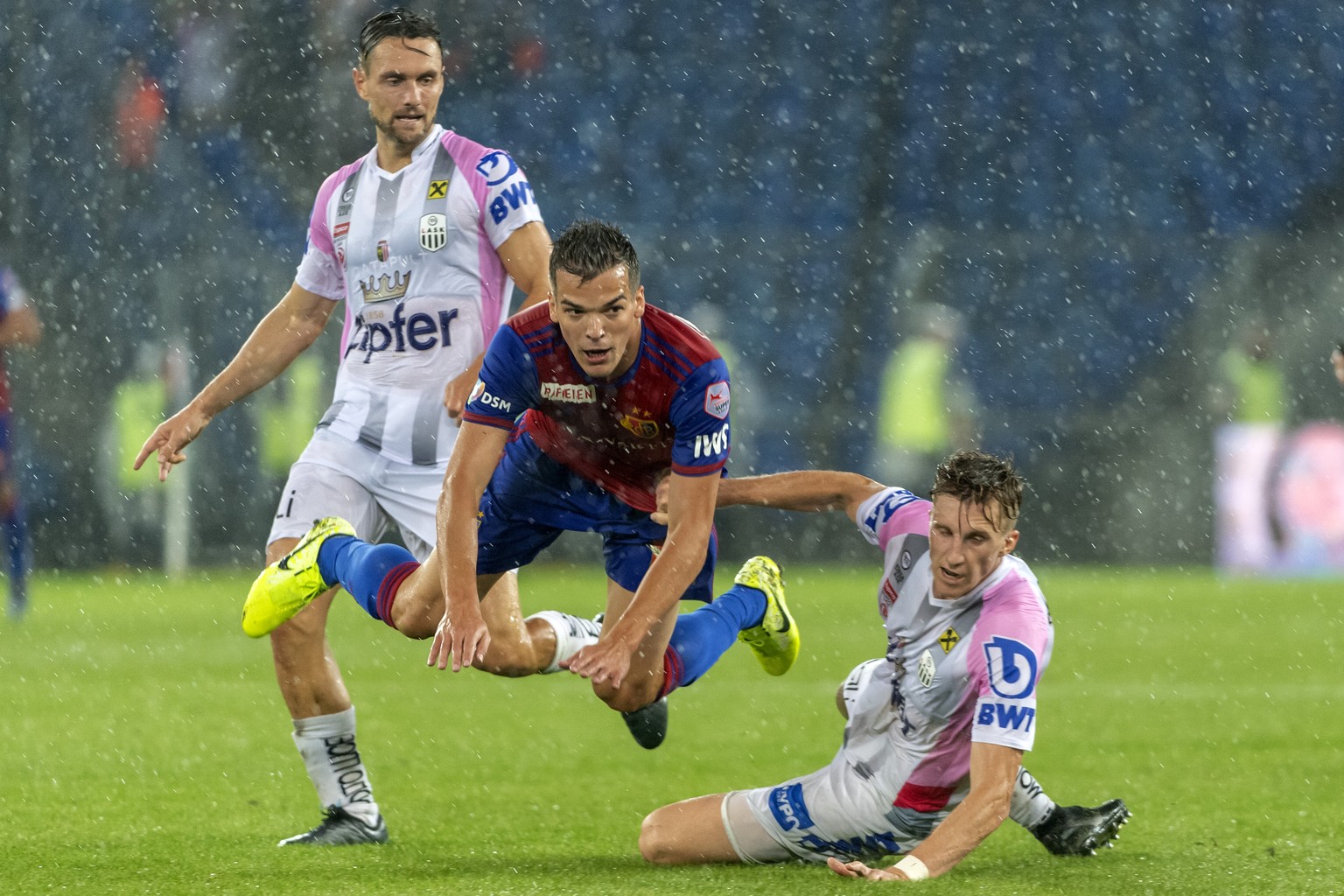 LASK&#039;s Rene Renner, Basel&#039;s Kevin Bua and LASK&#039;s Philipp Wiesinger, from left, during the UEFA Champions League third qualifying round first leg match between Switzerland&#039;s FC Base ...