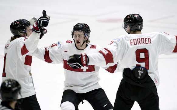 From left, Switzerland&#039;s Julien Privet, Dario Meyer and Marco Forrer celebrate the 2-0 goal by Meyer, during the 2016 World Junior Hockey Championships tournament match between Switzerland and Ca ...