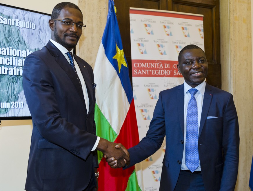 Foreign Minister of the Central African Republic Charles Armel Doubane, right, and Armel Mingatoloum Sayo head of the Revolution and Justice militia shake hands after signing the Political Agreement f ...