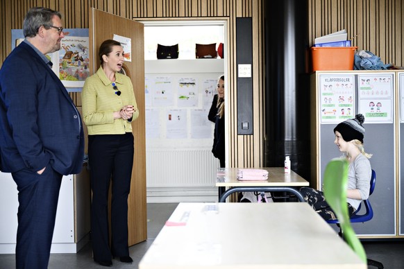 epa08363573 Danish Prime Minister, Mette Frederiksen (C), speaking with the pupils when she participates in the reopening of Lykkebo School in Valby in Copenhagen, Denmark, 15 April 2020. Starting 15  ...