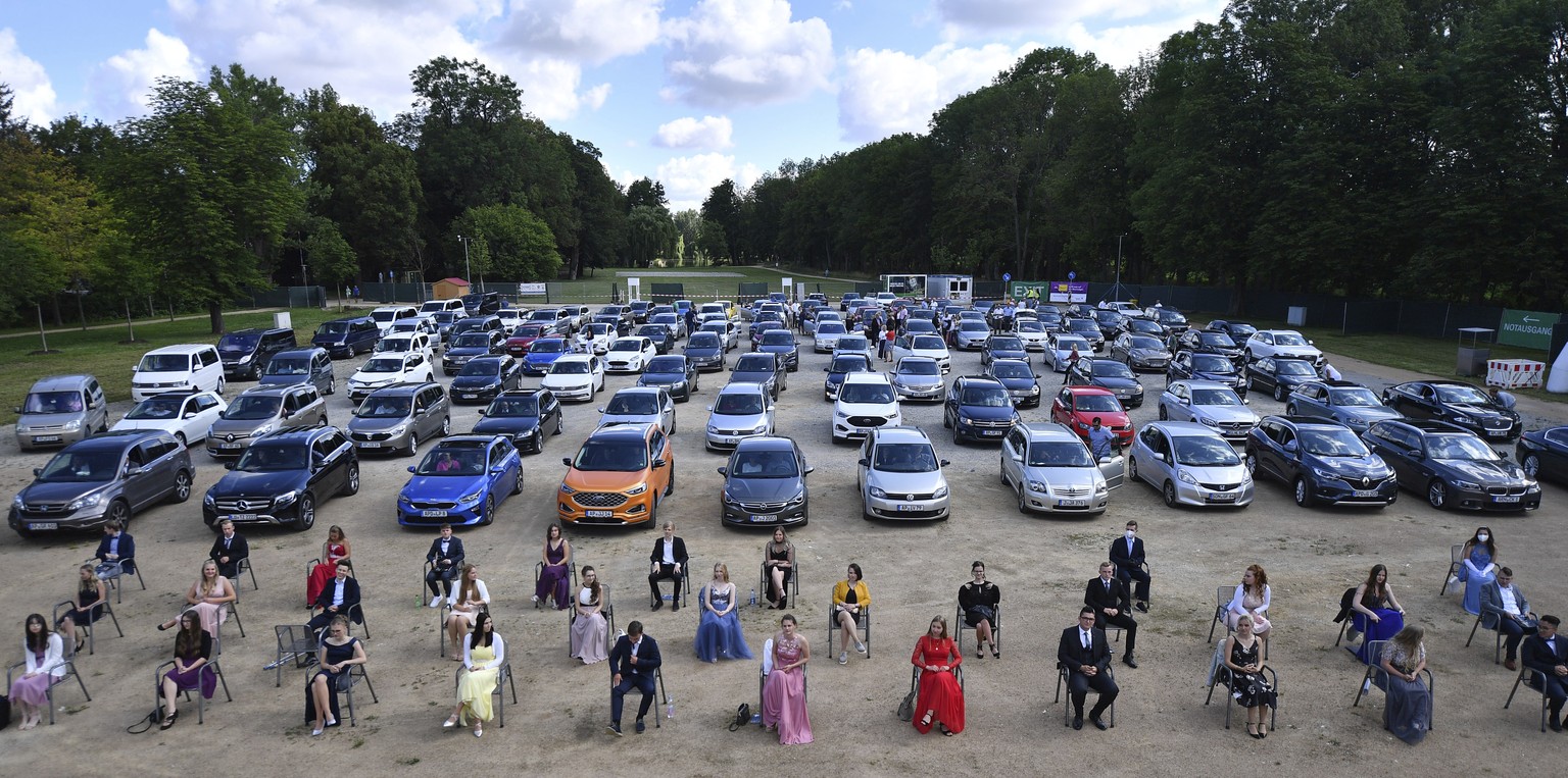 Pupils of the senior class of the high school Bergschule in Apolda, Germany, wait in a drive-in cinema for the presentation of their school-leaving certificates and honours on Saturday, July 11, 2020. ...