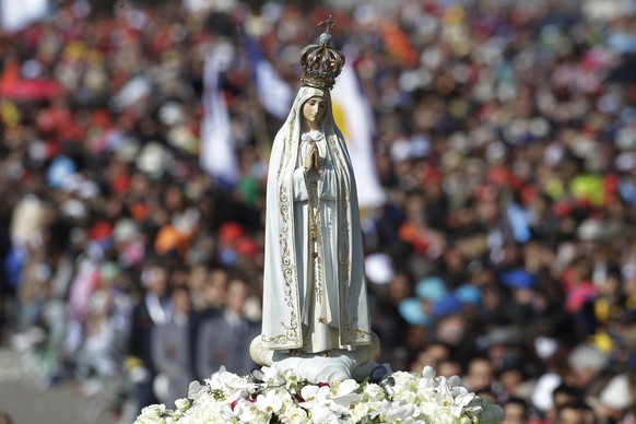 The statue of the Virgin Mary is shoulder carried by faithful prior to the start of a mass at the Sanctuary of Our Lady of Fatima Saturday, May 13, 2017, in Fatima, Portugal. The pontiff will canonize ...