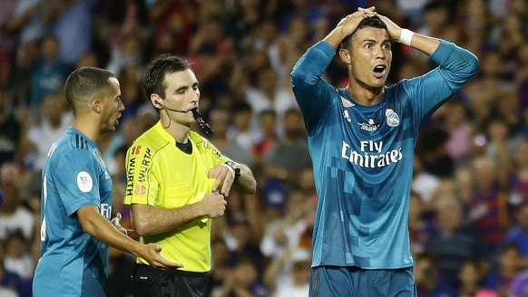 Real Madrid&#039;s Cristiano Ronaldo, right, reacts after Referee Ricardo de Burgos shows a yellow card during the Spanish Supercup, first leg, soccer match between FC Barcelona and Real Madrid at the ...