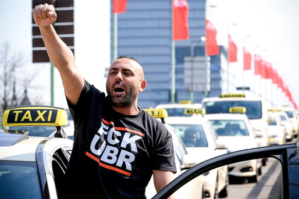 epa07495894 Taxi driver Ugur Durak shows his fist as his collegues drive slowly on a street during their nationwide protest in Cologne, Germany, 10 April 2019. Germany&#039;s Federal Ministry of Trans ...
