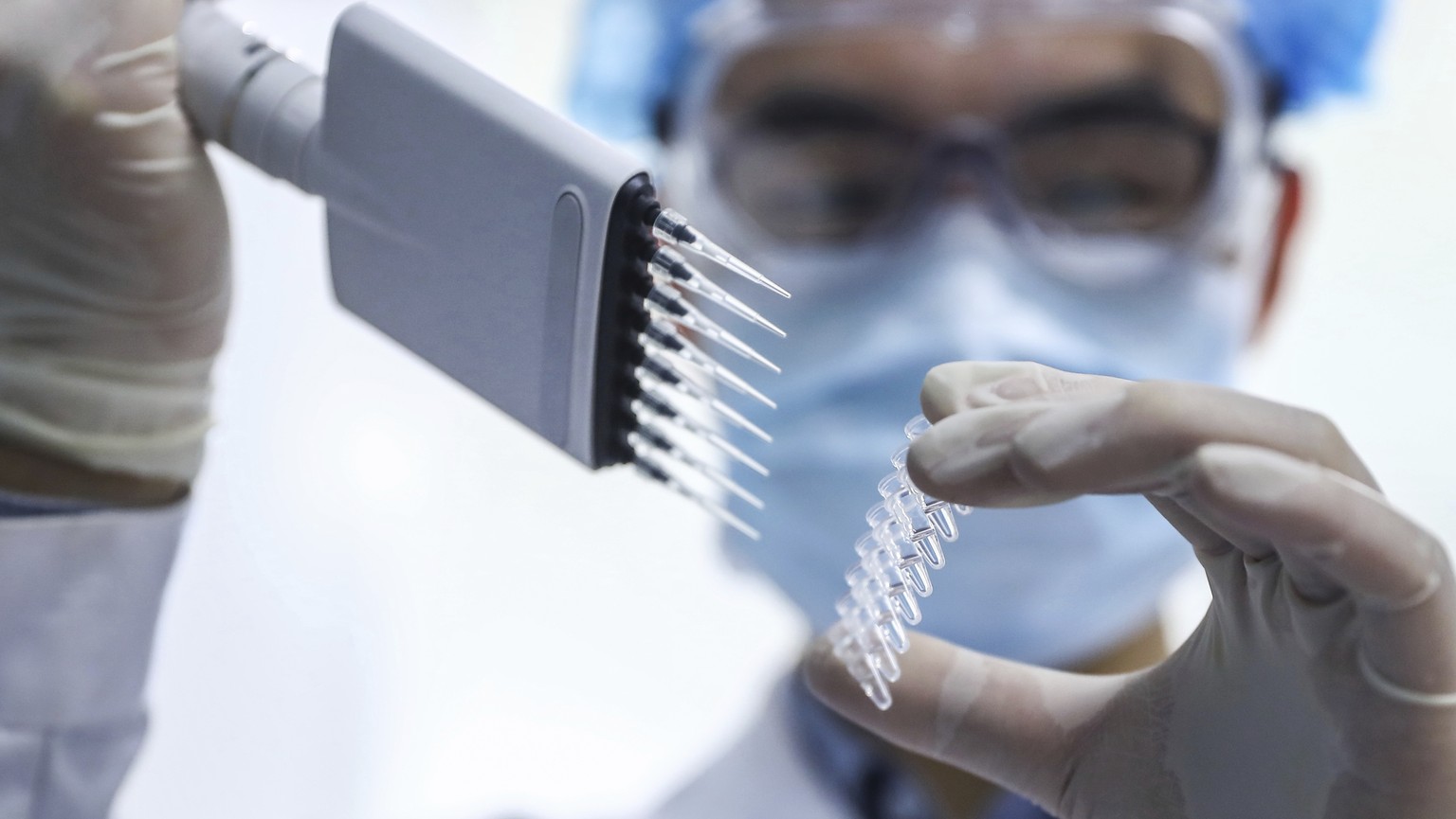 In this April 11, 2020 photo, released by Xinhua News Agency, a staff member tests samples of a potential COVID-19 vaccine at a production plant of SinoPharm in Beijing. In the global race to make a c ...