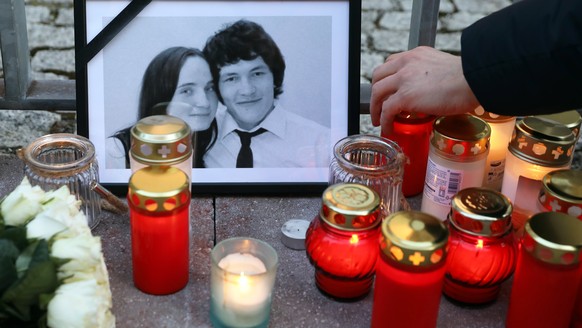 epa06575253 A man places a candle next to a portrait of murdered Slovak journalist Jan Kuciak and his fiance Martina Kusnirova during a vigil outside the Slovak Embassy in Berlin Germany, 02 March 201 ...