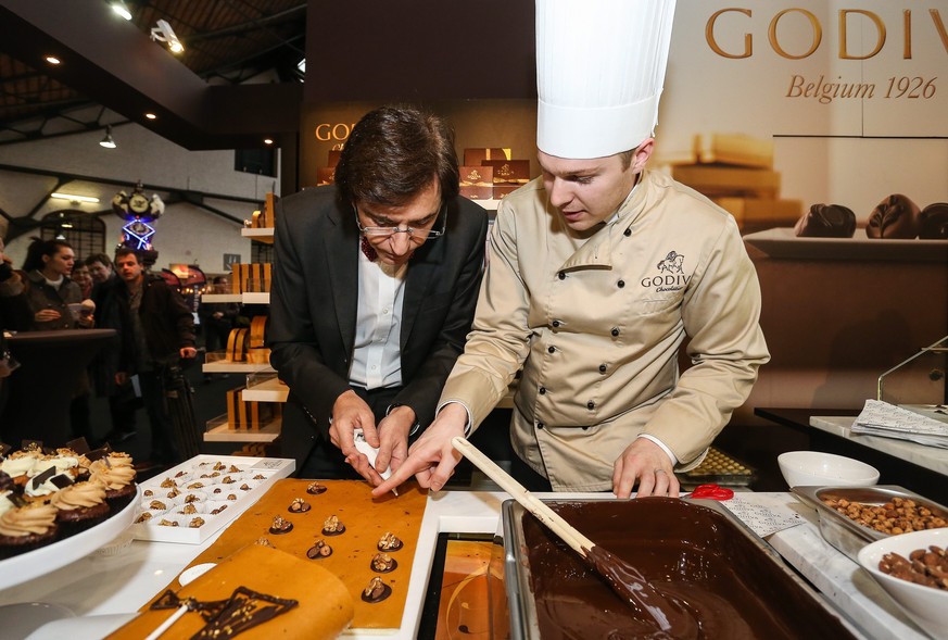 epa04059856 Belgian Prime Minister Elio Di Rupo (L) at chocolate manufacturer Godiva during a visit to the Chocolate fair, in Brussels, Belgium, 07 February 2014. The 20th Chocolate fair runs from 07  ...