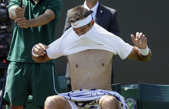 Juan Martin Del Potro of Argentina changes his shirt during the men&#039;s singles match against Peter Gojowczyk of Germany on the second day at the Wimbledon Tennis Championships in London, Tuesday J ...