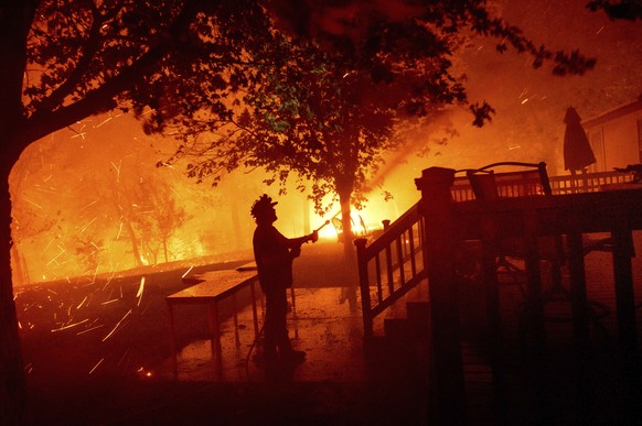 Matt Nichols sprays water while trying to save his home as the LNU Lightning Complex fires tear through Vacaville, Calif., on Wednesday, Aug. 19, 2020. Fire crews across the region scrambled to contai ...