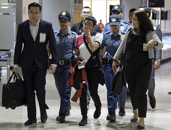 epa07469957 A handout picture made available by the Rappler shows Maria Ressa (C), CEO and Executive Editor of online news site Rappler and President of Rappler Holdings Corporation, being escorted by ...