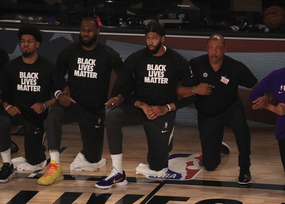 Los Angeles Lakers&#039; LeBron James, second from left, wears a Black Lives Matter shirt and kneels with teammates during the national anthem prior to an NBA basketball game against the Los Angeles C ...