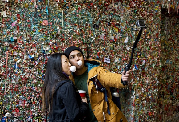 Jessica Wang, left, and Michael Teylan, both of Los Angeles, use a selfie stick at Seattle&#039;s &quot;gum wall&quot; at Pike Place Market, Monday, Nov. 9, 2015. On Tuesday, a steam-cleaning process  ...