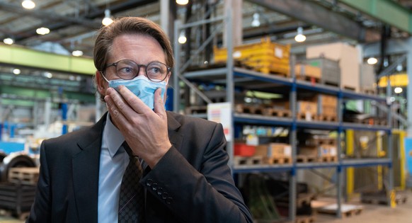 epa08675318 German Minister of Transport and Digital Infrastructure Andreas Scheuer adjusts his face mask during a press event on the structural change and sustainable development in Lusatia, at the D ...