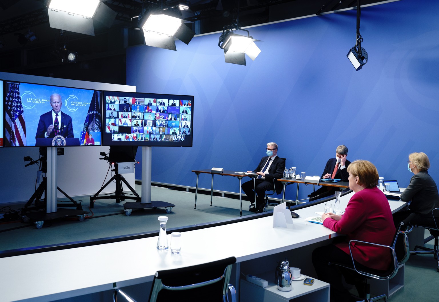 epa09152503 German Chancellor (2-R) Angela Merkel attends the virtual International Climate Summit with US President Joe Biden (on screen), in Berlin, Germant, 22 April 2021. The meeting is intended t ...